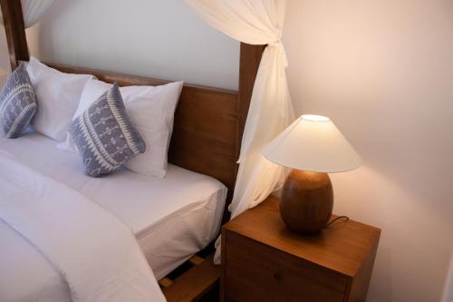 a bedroom with a bed and a lamp on a night stand at Sayang Sanur Duplex in Sanur