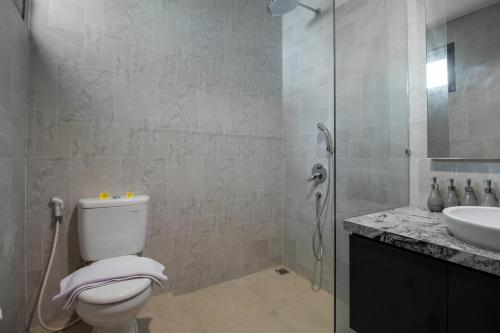 a bathroom with a toilet and a sink and a shower at Sayang Sanur Duplex in Sanur