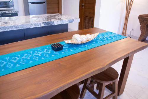 a wooden table with a plate of bread on it at Sayang Sanur Duplex in Sanur