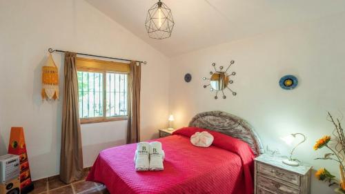 een slaapkamer met een rood bed en 2 handdoeken erop bij Casa Ameli Competa by Ruralidays in Cómpeta
