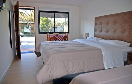 una camera d'albergo con due letti e una finestra di Trinidad Inn Flores a Trinidad