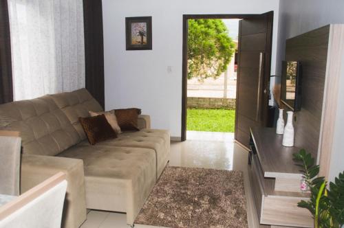 a living room with a couch and a table at Pousada Paraíso dos Canyons in Praia Grande