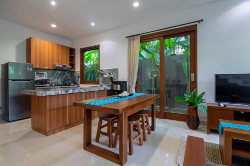 a kitchen with a wooden table and a counter at Sayang Sanur Duplex in Sanur