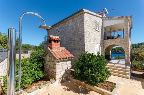 a brick building with a brick chimney and an archway at Apartment Jakov in Rogač