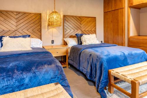 a bedroom with two beds and a desk and a chair at Casa Lavanda Hotel Boutique in Pátzcuaro
