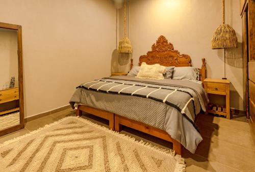 a bedroom with a large bed with a wooden headboard at Casa Lavanda Hotel Boutique in Pátzcuaro
