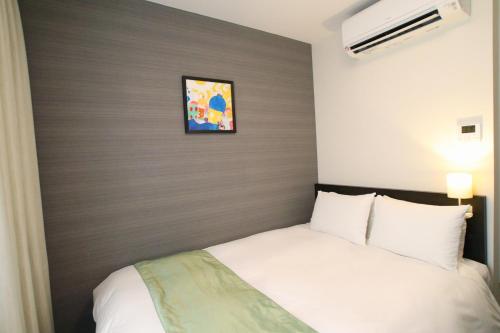a bedroom with a white bed with a brown headboard at Hotel Gran Ms Kyoto in Kyoto