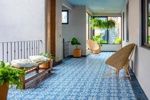 a hallway with chairs and plants on a floor at Casa Lavanda Hotel Boutique in Pátzcuaro