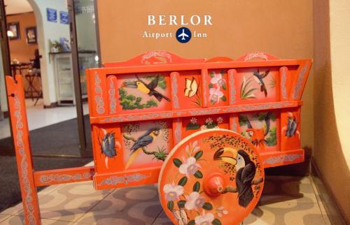 an orange shelf with birds on it in a store at Berlor Airport Inn in Alajuela City