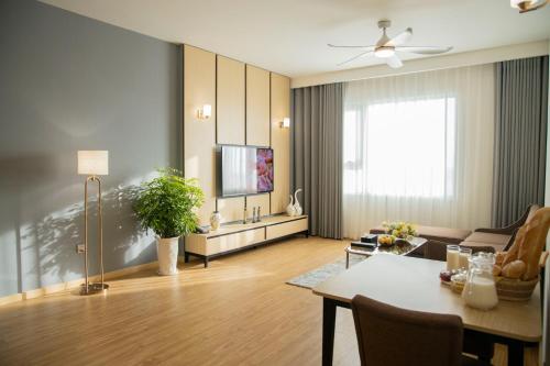 a living room with a table and a television at Pearl River Hotel in Hai Phong