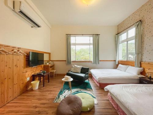 a hotel room with two beds and a television at Futen Villa in Sanyi
