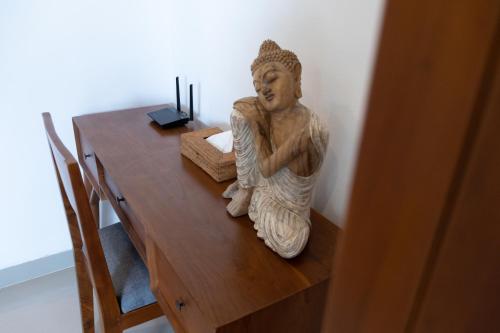 a statue sitting on top of a wooden table at Sayang Sanur Duplex in Sanur