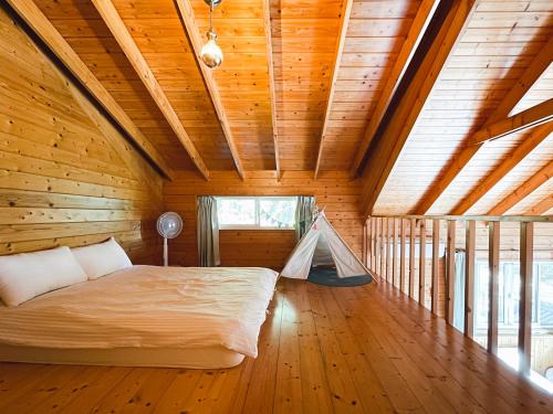a bedroom with a bed in a wooden room at Futen Villa in Sanyi