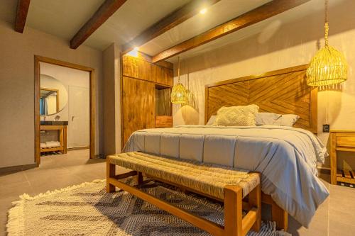 a bedroom with a large bed and a bench at Casa Lavanda Hotel Boutique in P&aacute;tzcuaro