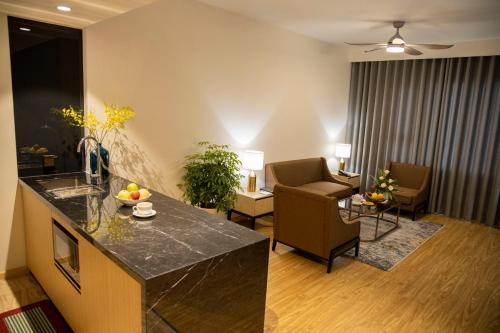 a living room with a kitchen and a living room with a table at Pearl River Hotel in Hai Phong