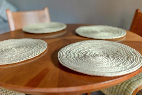 three white plates sitting on a wooden table at Casa Lavanda Hotel Boutique in Pátzcuaro