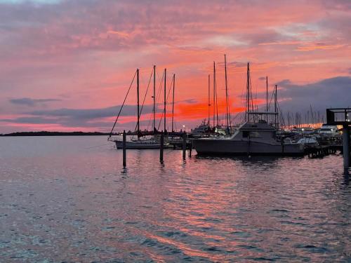 a group of boats docked at a dock with a sunset at Vistalmar Ocean Suites in Oranjestad