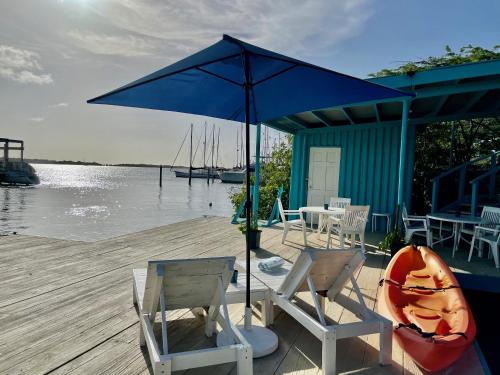 a couple of chairs and an umbrella on a dock at Vistalmar Ocean Suites in Oranjestad