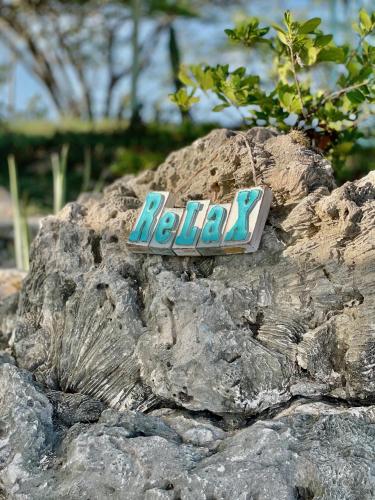 a sign sitting on top of a rock at Vistalmar Ocean Suites in Oranjestad