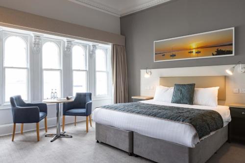 a hotel room with a large bed and a large window at The Great Western Hotel in Oban