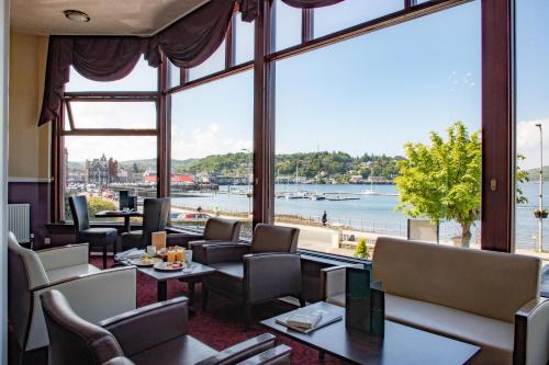 a living room filled with furniture next to a river at The Great Western Hotel in Oban