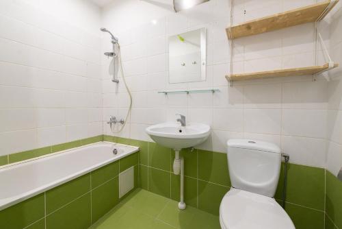 uma casa de banho verde e branca com um WC e um lavatório em Trendy Old Town Area - Paupys Nature Treat Apartment em Vilnius