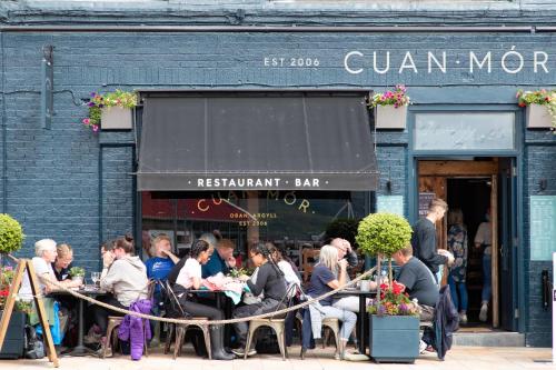 a group of people sitting at tables outside a restaurant at The Great Western Hotel in Oban