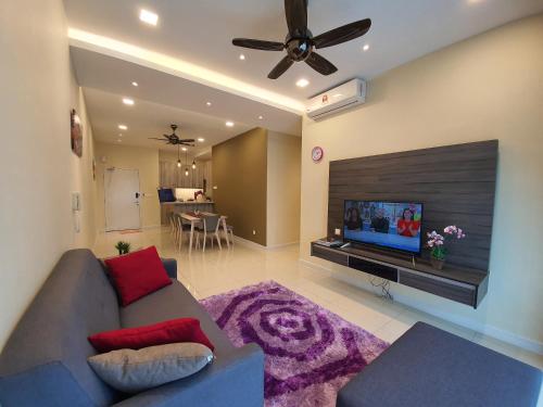 a living room with a couch and a flat screen tv at Southville Stay 2 @ Savanna Executive Suite in Kampong Tangkas