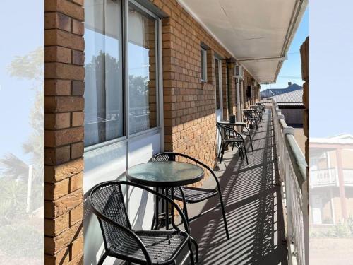 a balcony with tables and chairs on a building at Grand Hotel Motel in Clermont