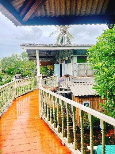 a wooden walkway leading to a building at นิทานคำกลอน 2 Nithankumkon 2 in Amphawa