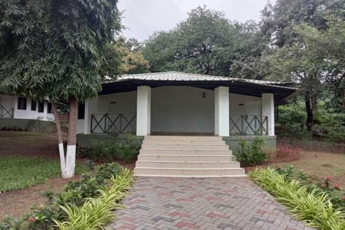 a small white house with stairs in front of it at White Feather Resort Kauncha in Silvassa