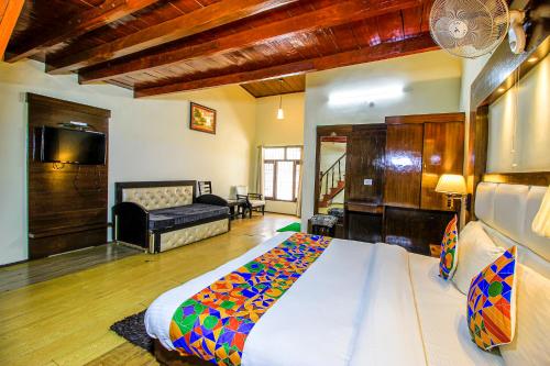 a bedroom with a large bed and a living room at FabHotel Moon II in Nainital