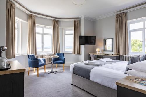 a hotel room with a bed and a desk and chairs at The Imperial Hotel Exmouth in Exmouth