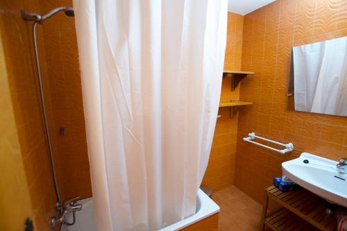 a bathroom with a shower curtain and a sink at Casa 4 vents in Escardacs