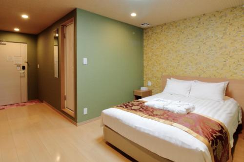 Un dormitorio con una cama grande y una pared verde en Arakawa-ku - Hotel / Vacation STAY 21942, en Tokio