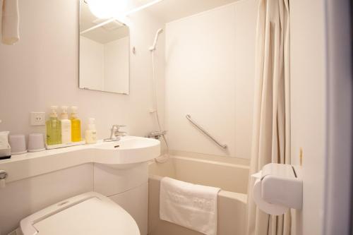 Baño blanco con aseo y lavamanos en Arakawa-ku - Hotel / Vacation STAY 21942 en Tokio