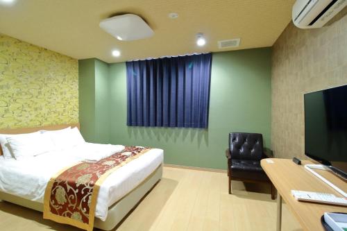Arakawa-ku - Hotel / Vacation STAY 21942 في طوكيو: غرفة نوم مع سرير ومكتب مع جهاز كمبيوتر