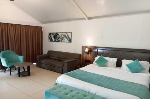 Habitación de hotel con cama y sofá en White Feather Resort Kauncha en Silvassa
