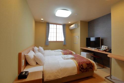 Dormitorio con cama, escritorio y TV en Arakawa-ku - Hotel / Vacation STAY 22248, en Tokio
