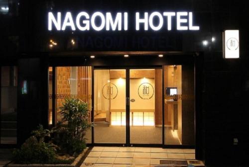 東京にあるArakawa-ku - Hotel / Vacation STAY 22248の夜間のドアの上に看板を持つホテル