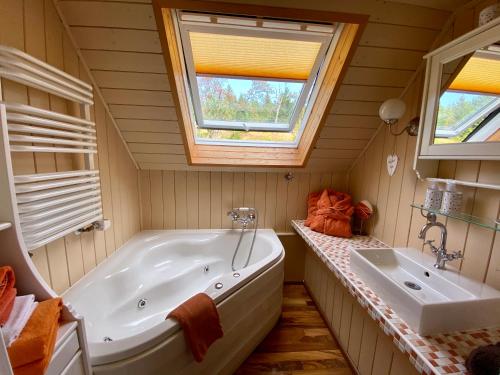 a bathroom with a tub and a sink and a window at Die Adlerhütte in Kurort Oberwiesenthal