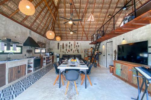 a kitchen with a table with chairs and a tv at aldea pukna in Akumal