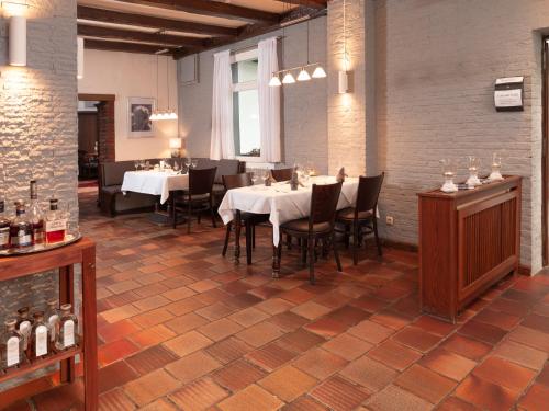 a dining room with tables and chairs in a building at Hotel Haus Gimken in Essen