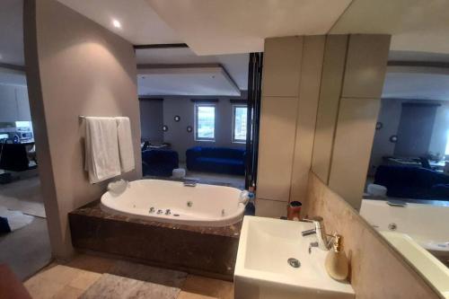 a large bathroom with a tub and a sink at Exquisite Apartment with Jaccuzzi Pool Table and Cinema in Johannesburg
