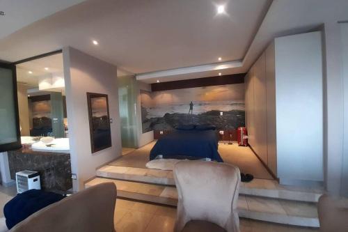 a bedroom with a bed with a painting on the wall at Exquisite Apartment with Jaccuzzi Pool Table and Cinema in Johannesburg