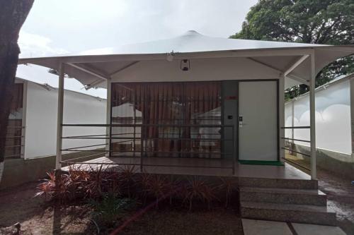 a small building with a white awning on top of it at White Feather Resort Kauncha in Silvassa