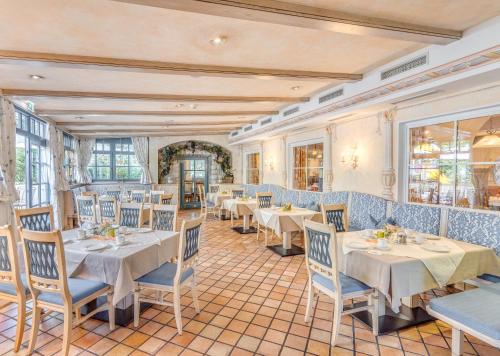 a restaurant with white tables and blue chairs at Gasthof Schorn in Sankt Leonhard