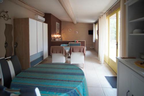 a room with a table and chairs and a kitchen at La Pitchounette Mas Val-Chênaie Gordes in Gordes