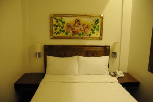 a bedroom with a bed and a picture on the wall at Hotel Veneto De Vigan in Vigan