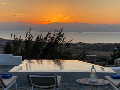 una piscina con vistas al océano al atardecer en Nisides Villa Kostos en Kóstos